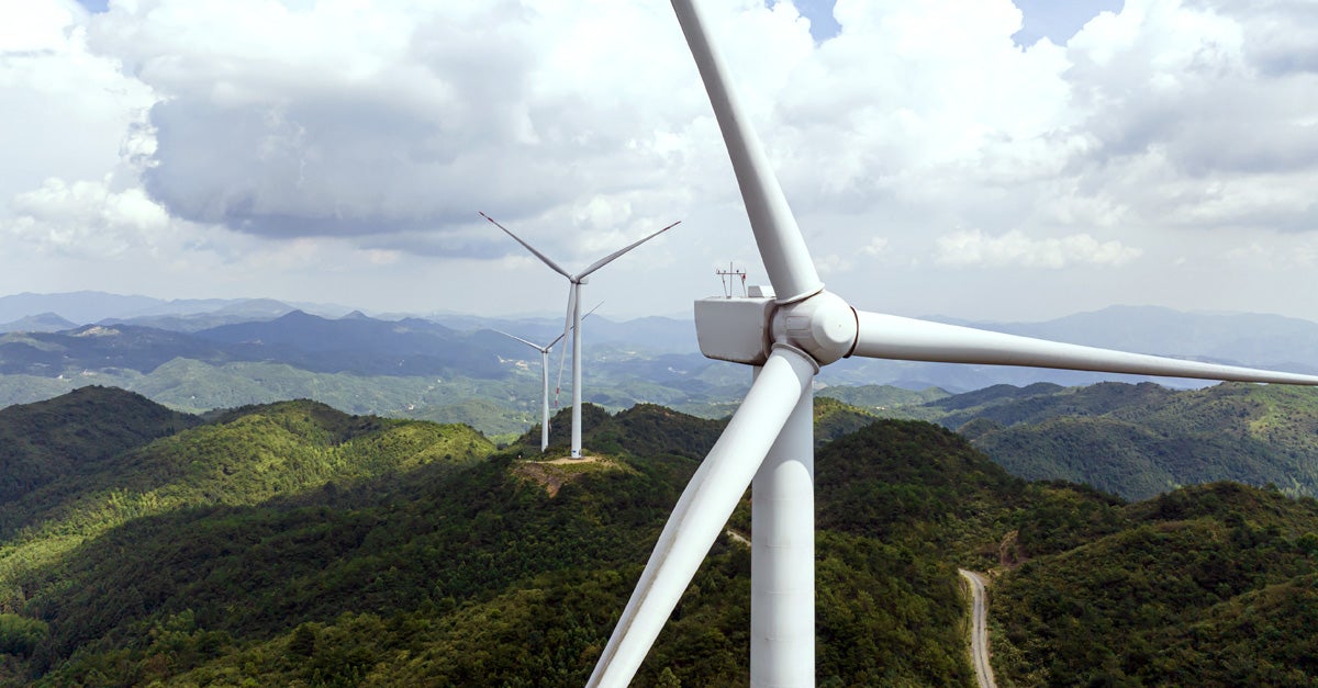 sustainable energy windmills on forest covered hills