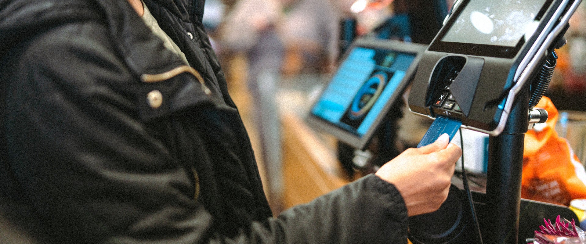person paying at POS system with credit card