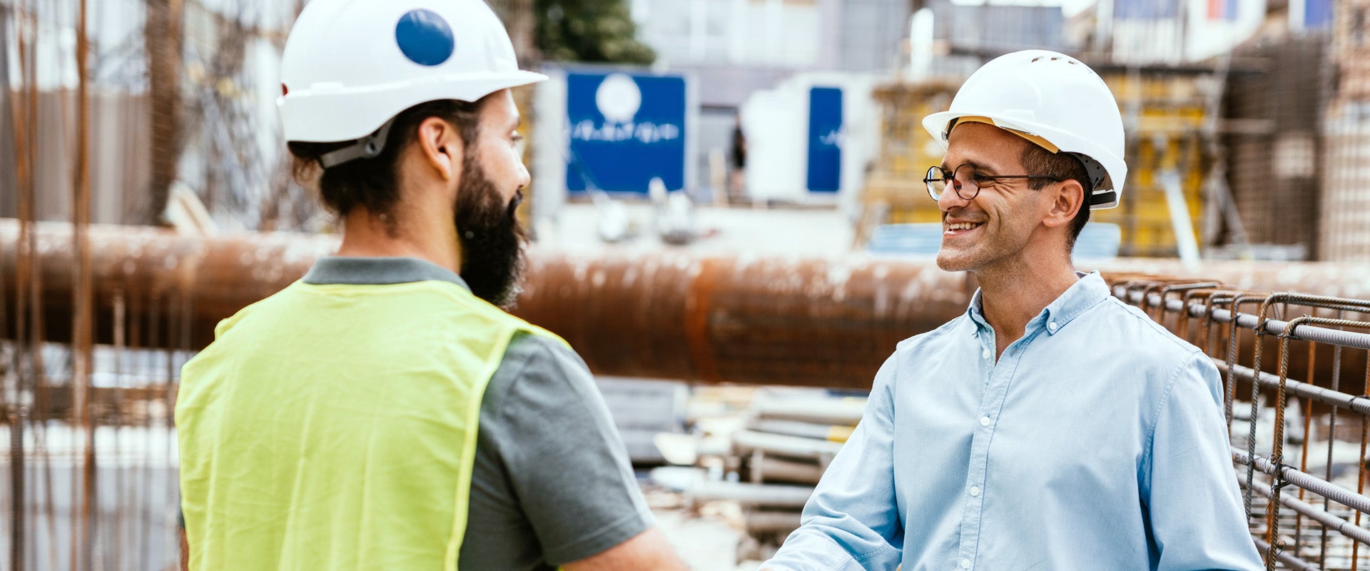 Two men shaking hands in a processing facility