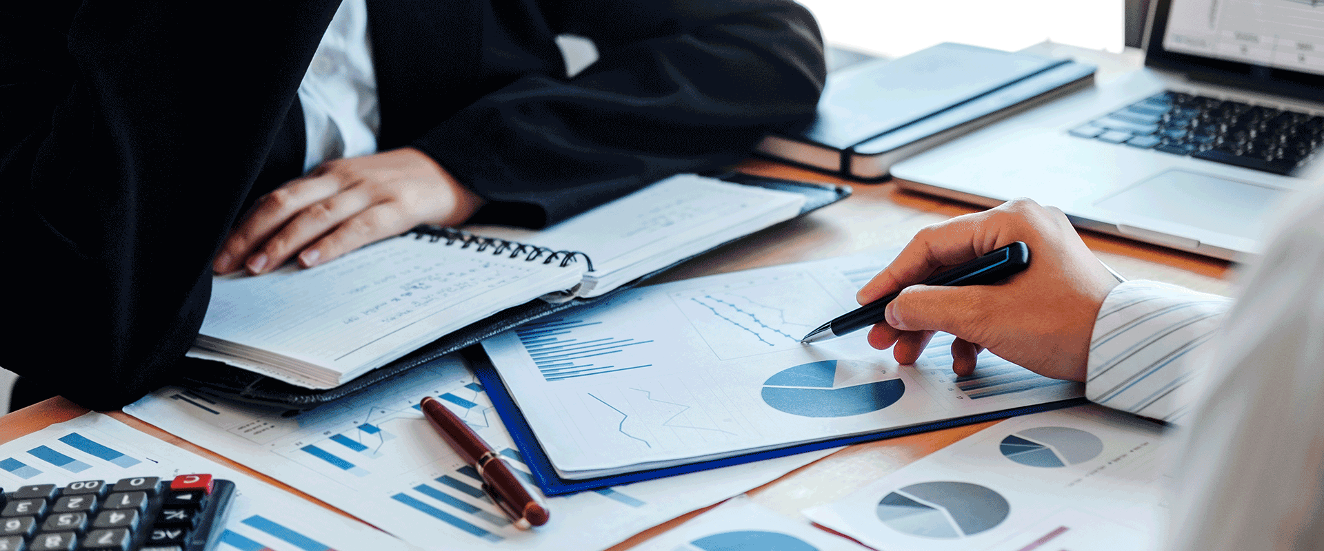two people meeting over charts and graphs