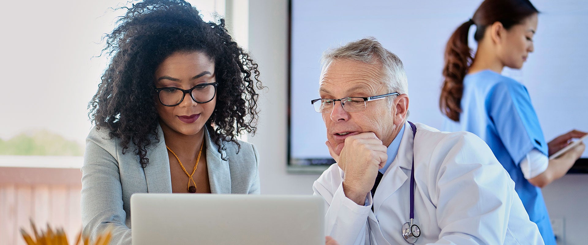 doctors conversing over laptop