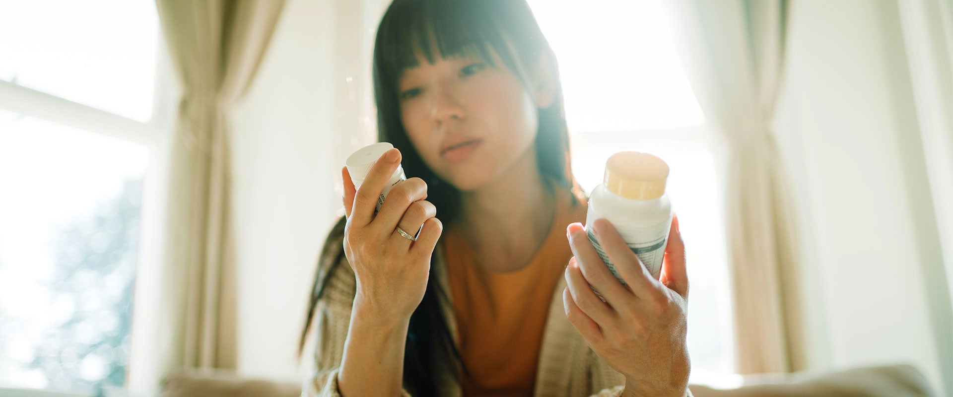 woman holding pill bottles