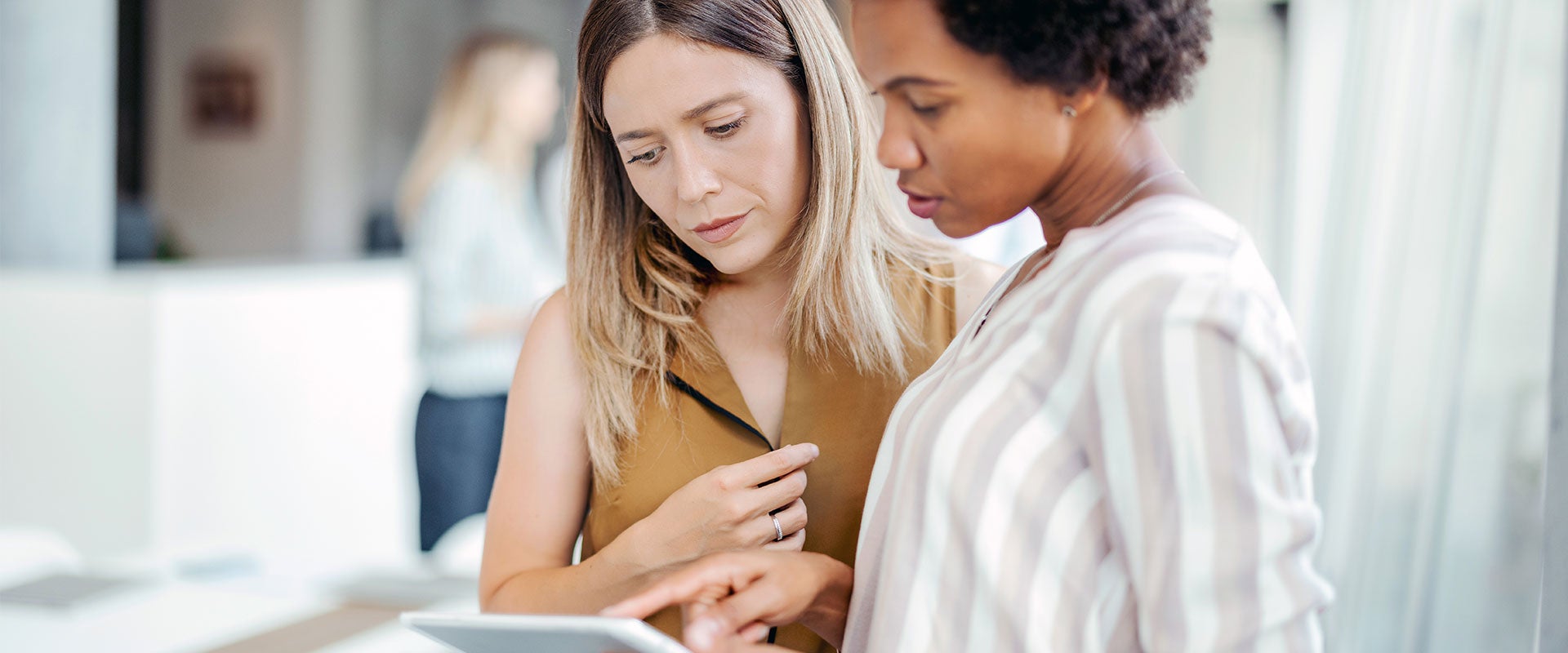 two women looking at tablet