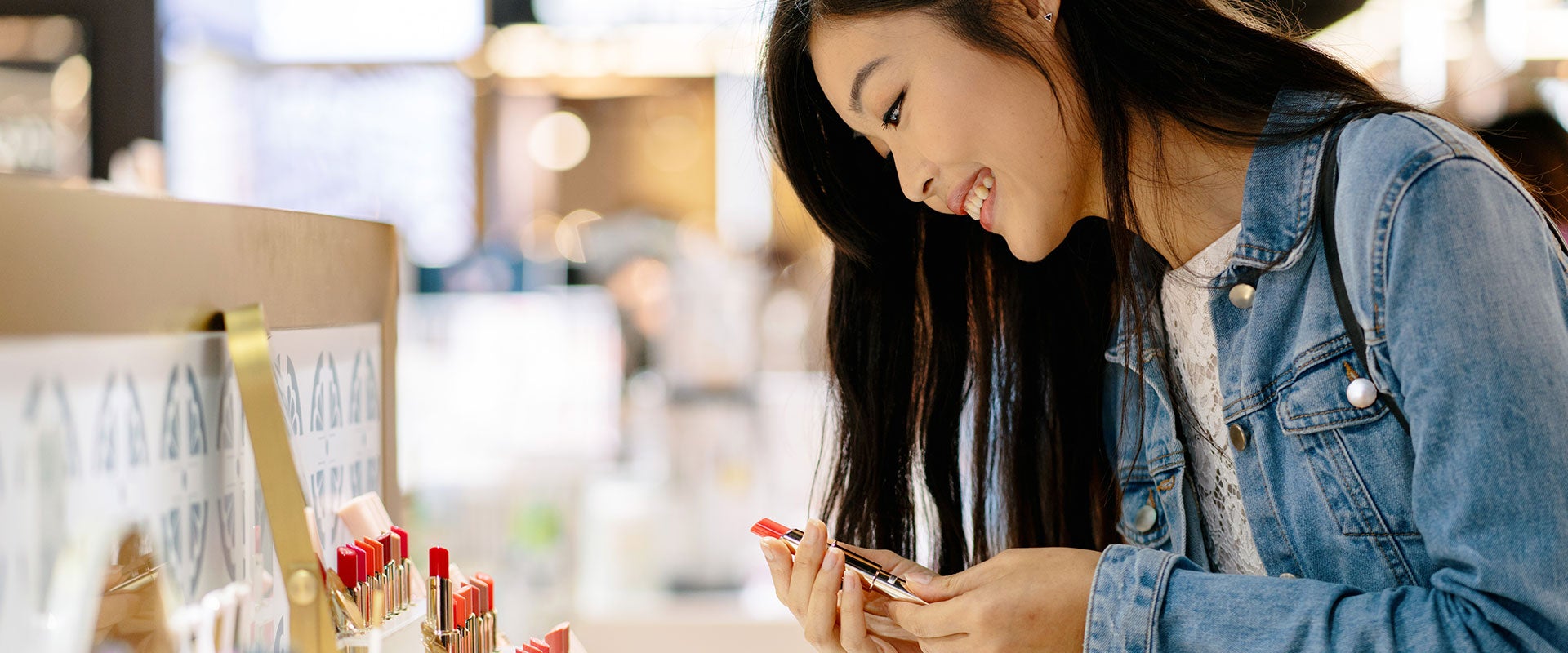 smiling person holding lipstick