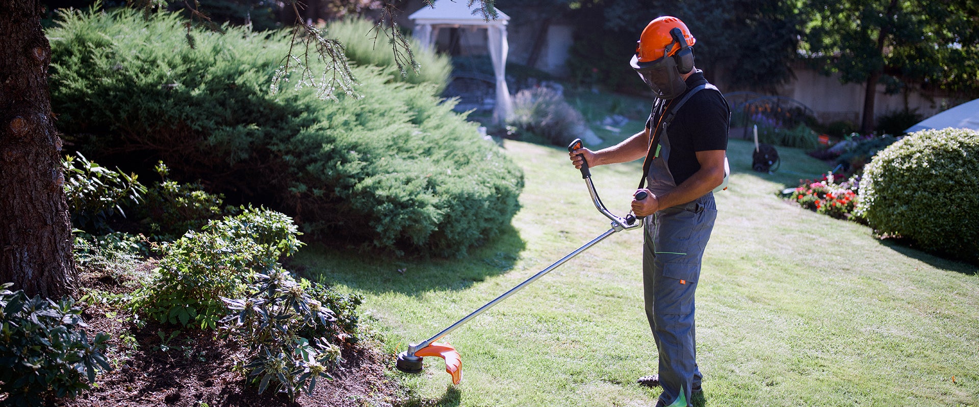 man using edger to trim lawn