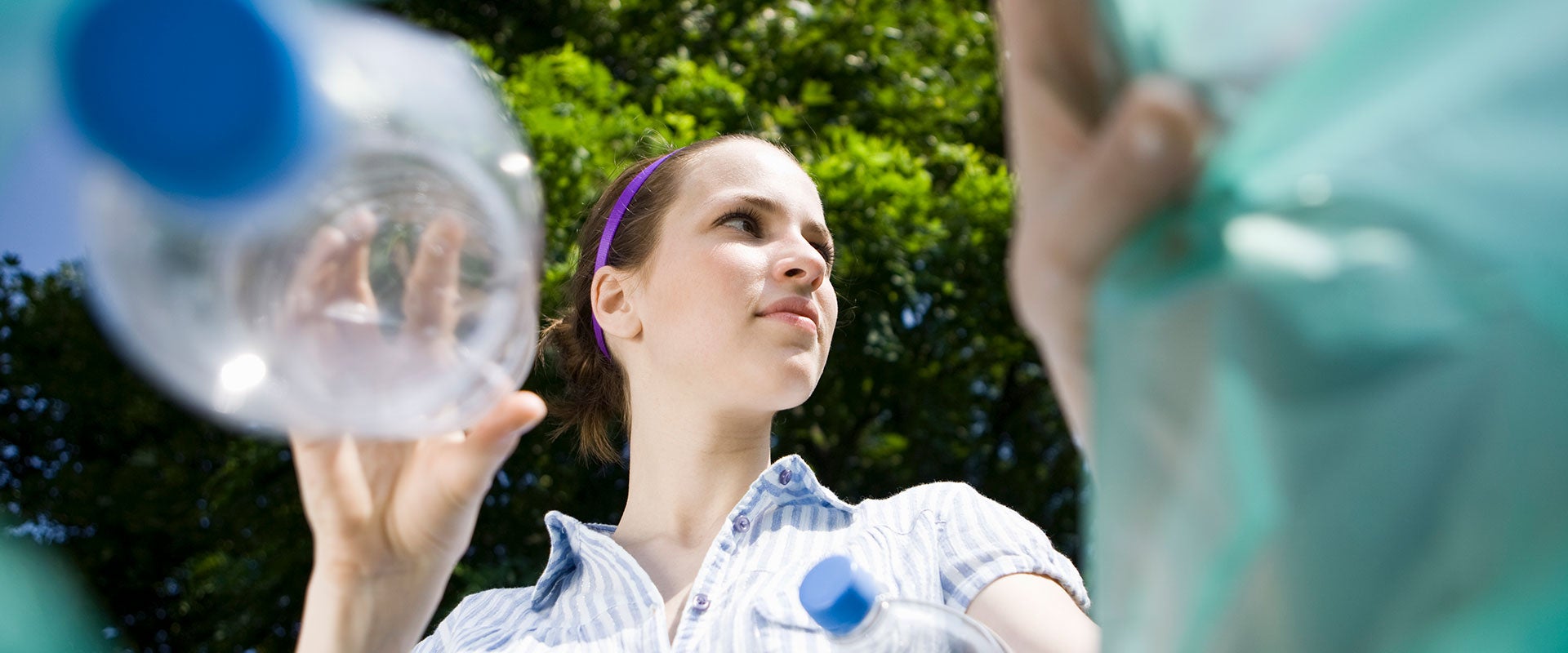 woman throwing away plastic bottle