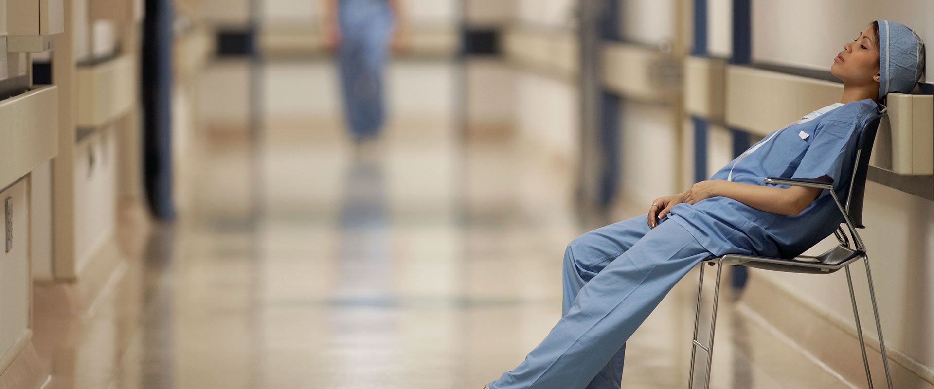 nurse leans against wall