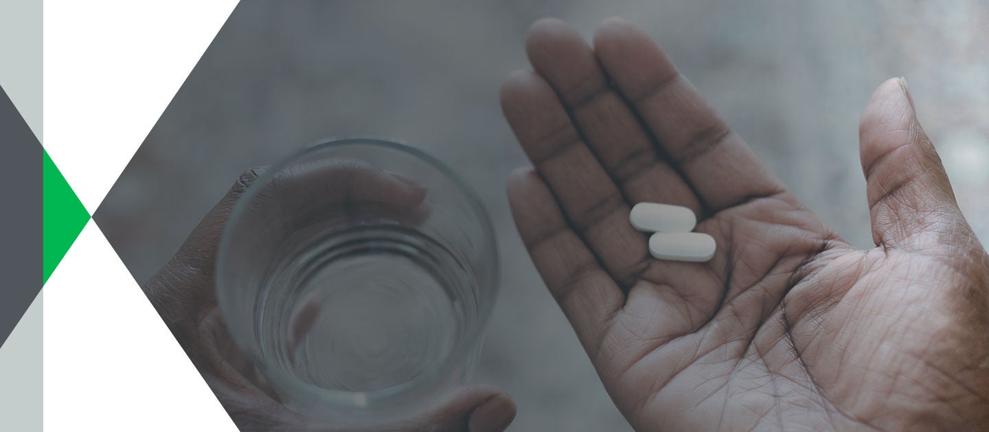 hands holding pills and water