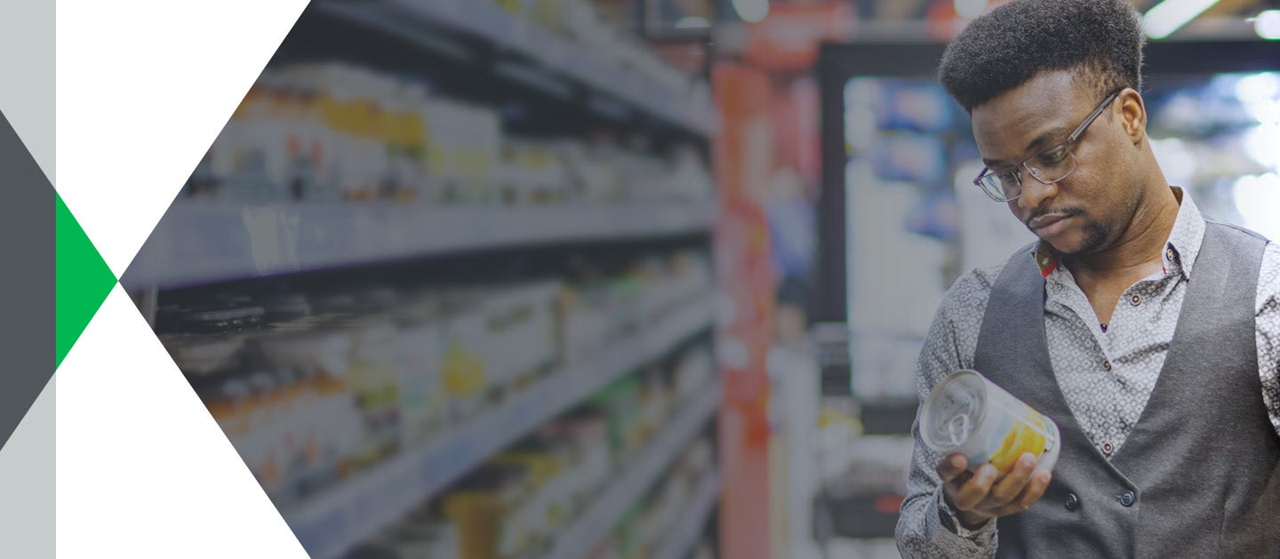 Man standing in grocery store looking at label on can of food