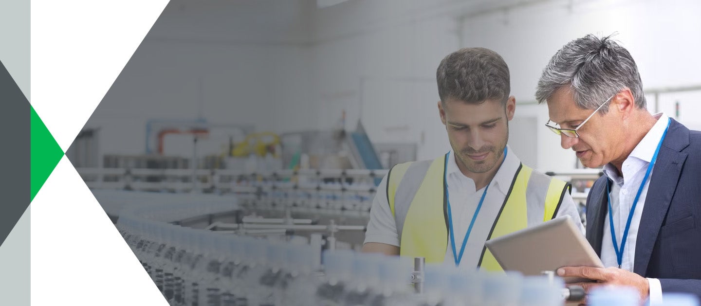Two people inspecting assembly line in bottling plant
