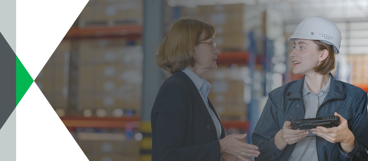 woman in suit talking to woman in hard hat