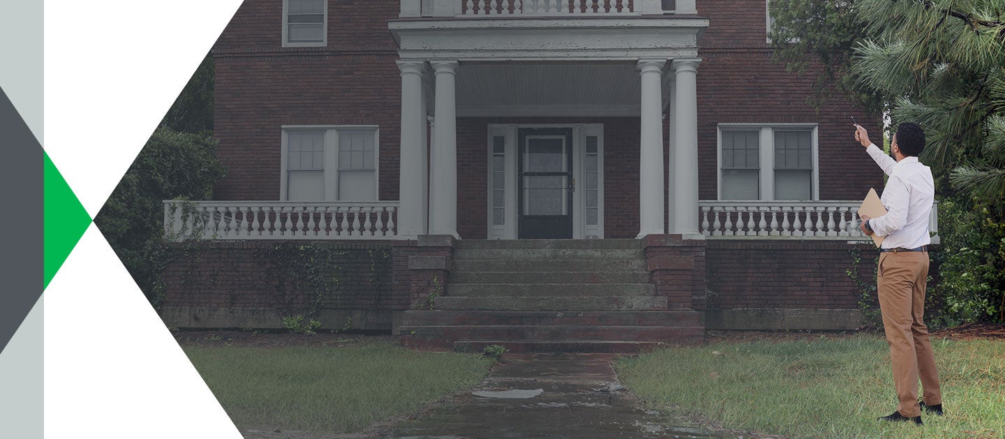 man assessing home exterior