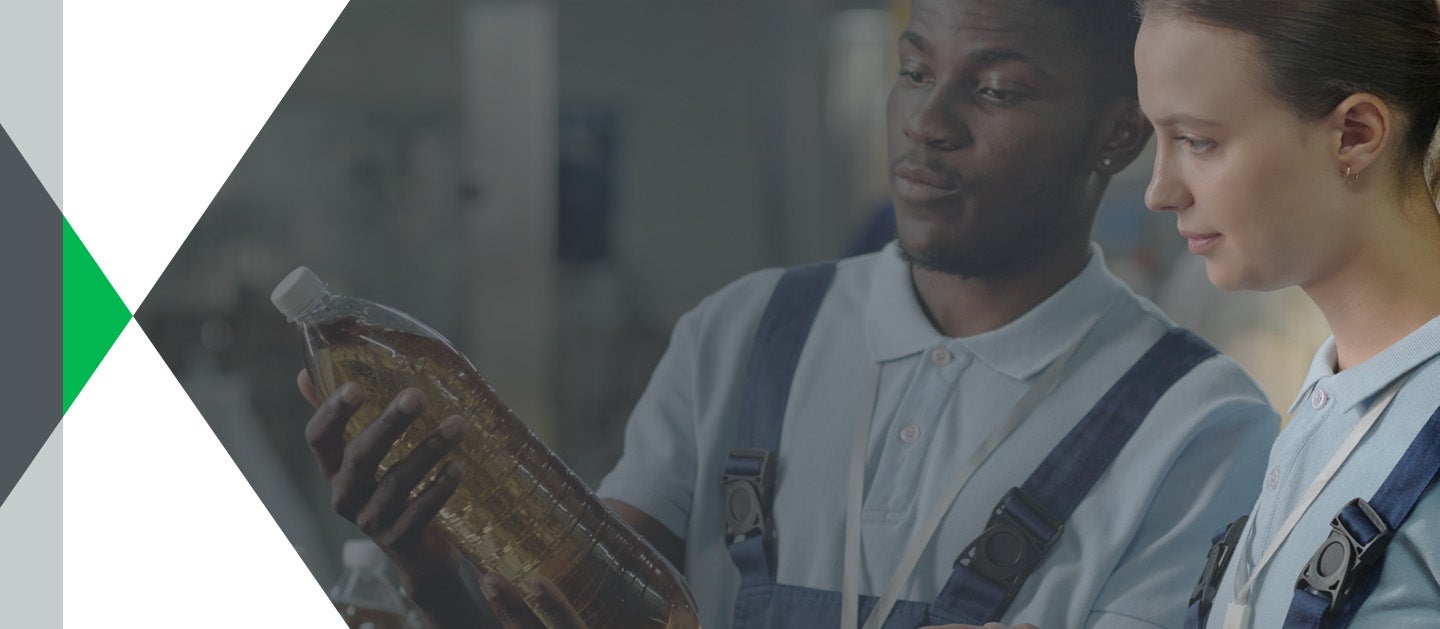 Two bottling plant workers inspecting bottle