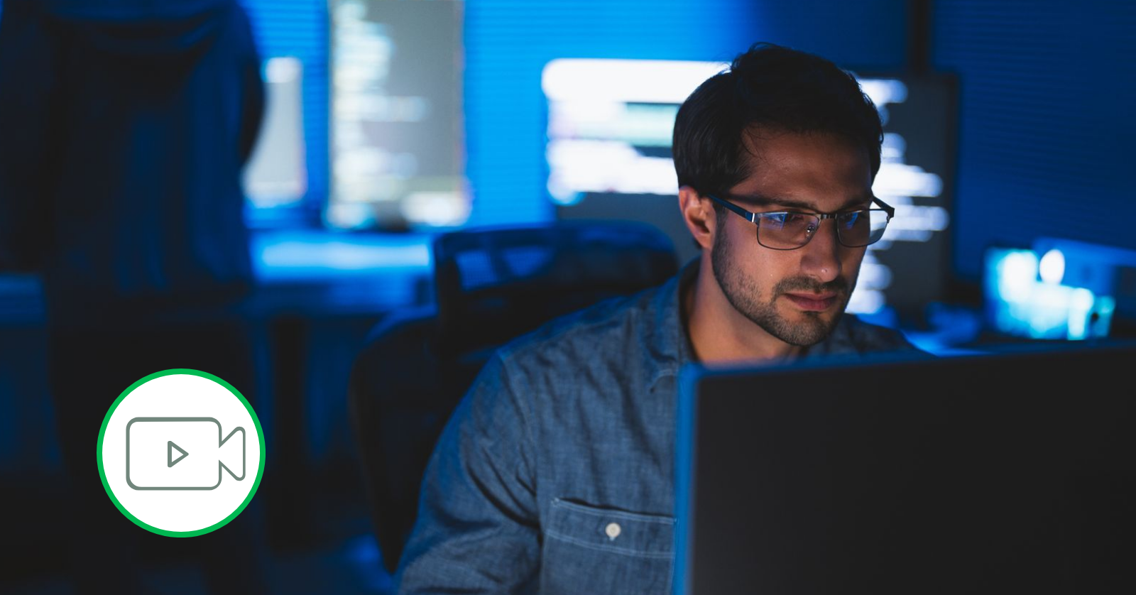 man using laptop in dark room 