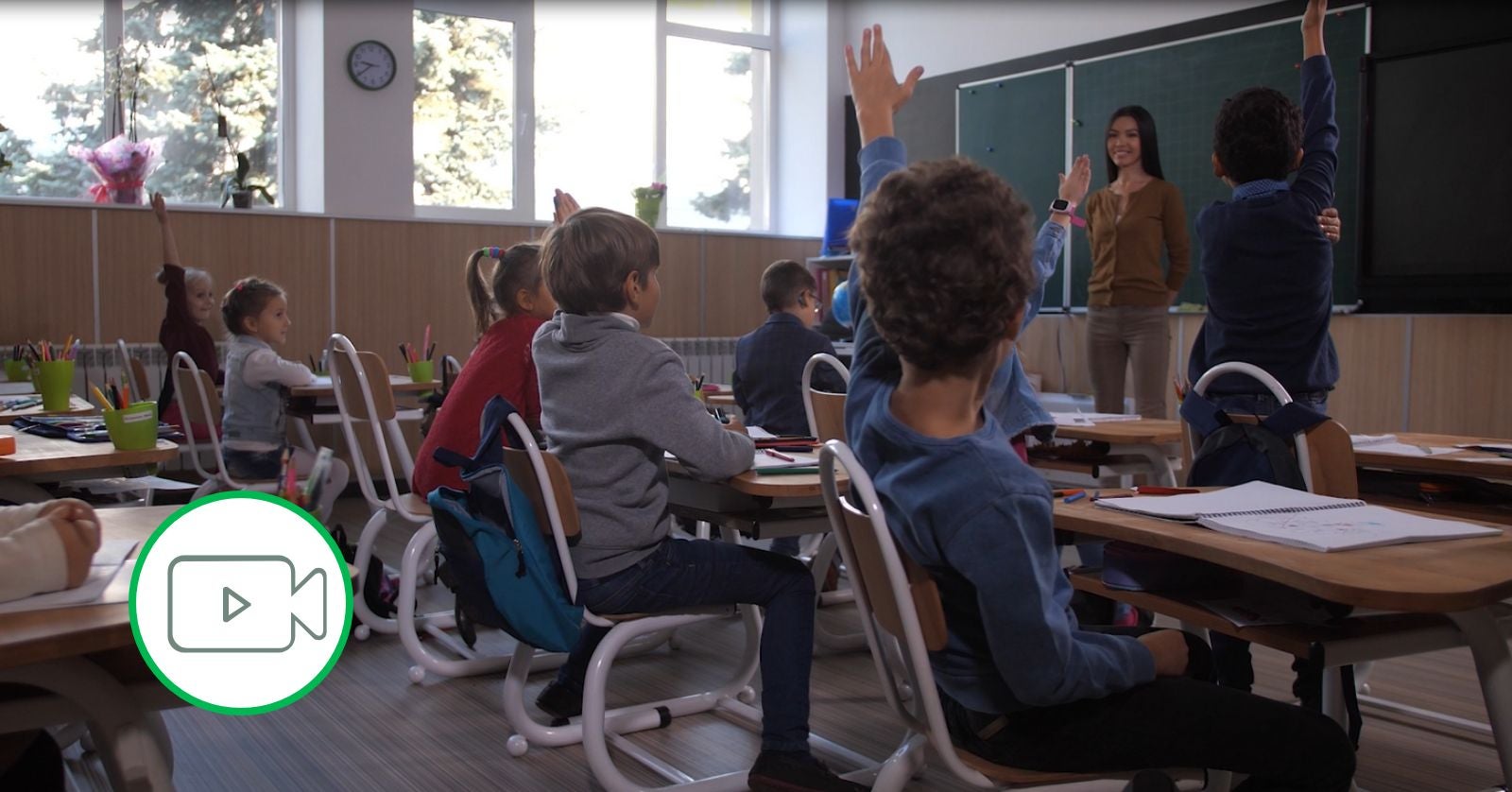 students raising hands in classroom