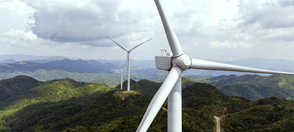 sustainable energy windmills on forest covered hills